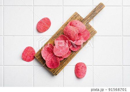 Red potato chips on white ceramic squared tile table background, top view flat lay, with copy space for text Red potato chips on white ceramic squared tile table background, top view flat lay, with copy space for text 91568701