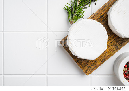 Camembert and brie cheese on white ceramic squared tile table background, top view flat lay, with copy space for text 91568862