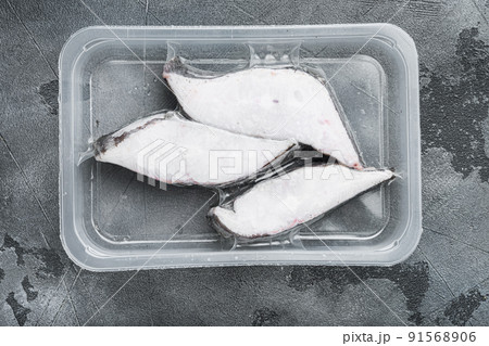 Halibut fish frozen steak pack, on gray stone table background, top view flat lay 91568906