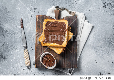 Toast with chocolate Hazelnut spread on wooden board. Gray background. Top view 91571336