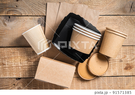 Disposable paper tableware. Eco friendly Recycling set of paper cups, dishes, bag, fast food containers and cutlery. Wooden background. Top view. Copy space 91571385