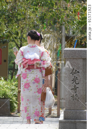 古都の橋のたもとで話に夢中になる着物姿の女性 91571923