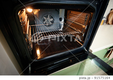 Open built-in oven with lighting in the home kitchen Open built-in oven with lighting in the home kitchen 91575164