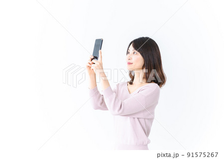 笑顔でスマホ撮影をする若い女性 91575267