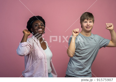 Guy and woman smiling at camera gesturing with fist 91575907