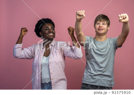 Smiling woman and guy with raised fists 91575910