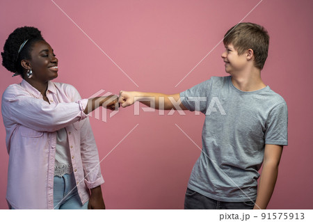 Guy and woman standing opposite touching fist 91575913