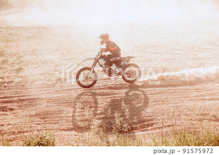 Live shot of male sportsman training on motorbike at hot summer day, outdoors. Motocross rider in action. Motocross sport 91575972