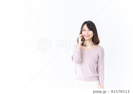 笑顔で電話をかける若い女性 笑顔で電話をかける若い女性 91576513
