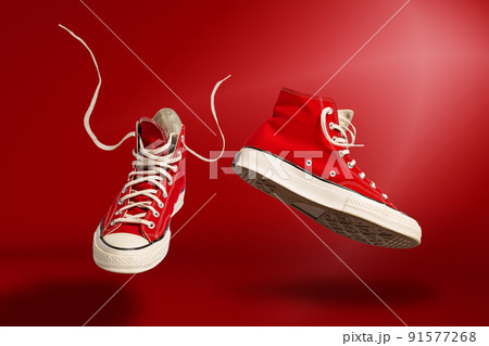 Flying sneakers on red background. Sport shoes or trainers isolated. Athletic shoes. fitness, sport, training concept. Urban fashion 91577268