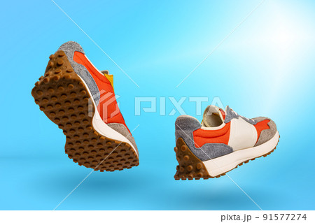 Urban sports shoes over blue background. Sneakers or trainers isolated. Athletic shoes. fitness, sport, training concept. Urban fashion 91577274