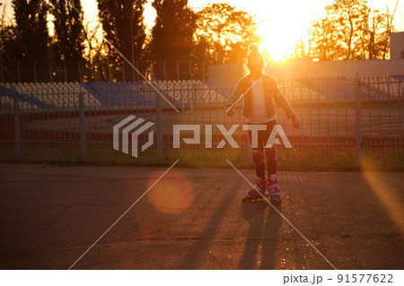 Girl riding roller skates in the park 91577622