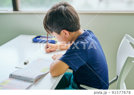 ノートに書き取りをする小学生の男の子 91577678