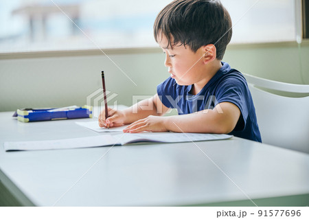 ノートに書き取りをする小学生の男の子 ノートに書き取りをする小学生の男の子 91577696