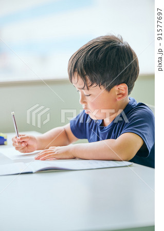 ノートに書き取りをする小学生の男の子 91577697