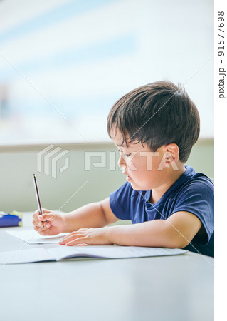 ノートに書き取りをする小学生の男の子 91577698