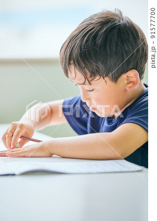 ノートに書き取りをする小学生の男の子 91577700
