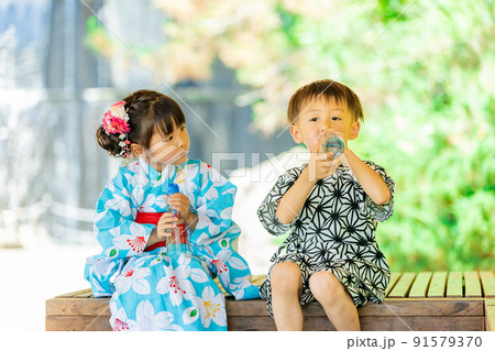 スイカを食べる浴衣姿の女の子と甚平姿の男の子 スイカを食べる浴衣姿の女の子と甚平姿の男の子 91579370