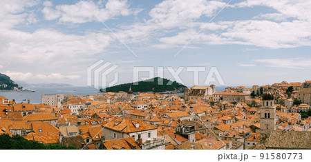 Panoramic view of the whole old city of Dubrovnik. View from the wall to the tiled roofs. Panoramic view of the whole old city of Dubrovnik. View from the wall to the tiled roofs. 91580773