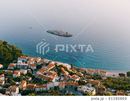 Aerial view of the houses of the seaside town among greenery 91580869