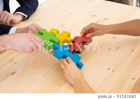Business people assembling puzzle Business people assembling puzzle 91581085