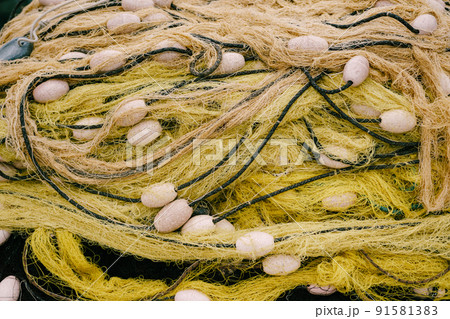 Folded yellow fishing net with white floats. Close-up Folded yellow fishing net with white floats. Close-up 91581383