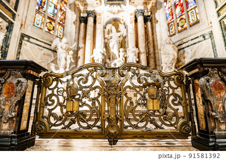 Carved gates with gilding in front of the altar of St. John in the Duomo. Milan, Italy 91581392