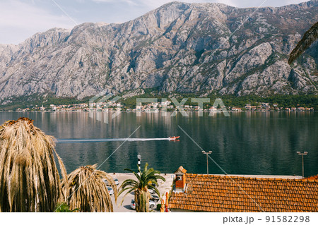 Boat sails along the Bay of Kotor against the backdrop of mountains Boat sails along the Bay of Kotor against the backdrop of mountains 91582298