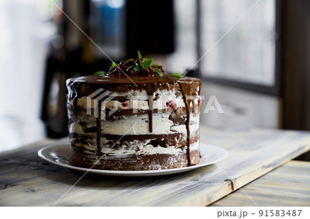 Chocolate brownie cake topped with dark chocolate ganache on a wooden table 91583487
