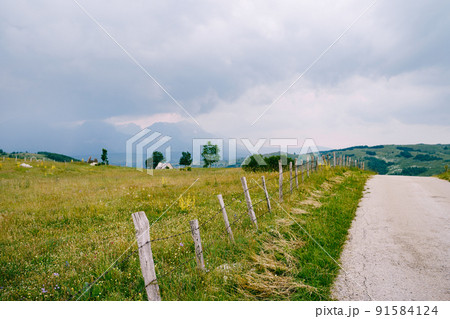 Barbed wire fence along a mountain road in a valley in northern Montenegro Barbed wire fence along a mountain road in a valley in northern Montenegro 91584124