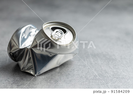 Empty crumpled can on gray table. Empty crumpled can on gray table. 91584209