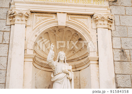 Statue of Jesus Christ in an arched niche near the Church of the Nativity of the Virgin in Prcanj Statue of Jesus Christ in an arched niche near the Church of the Nativity of the Virgin in Prcanj 91584358