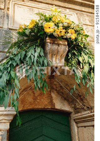 Flower-adorned entrance to the old stone church 91584588