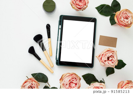 Creative workplace layout with blank screen tablet, flowers, business card. Female workspace mockup Creative workplace layout with blank screen tablet, flowers, business card. Female workspace mockup 91585213