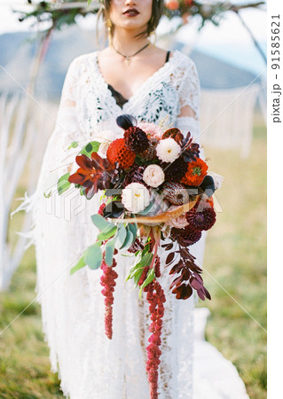 Bride with a bouquet of flowers stands near the wedding arch Bride with a bouquet of flowers stands near the wedding arch 91585621