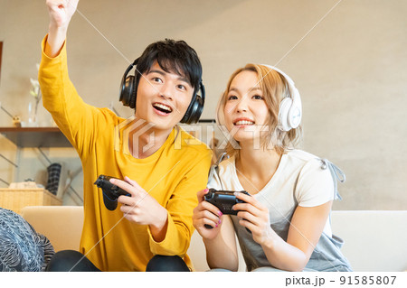 テレビゲームで遊ぶ若い男女 テレビゲームで遊ぶ若い男女 91585807