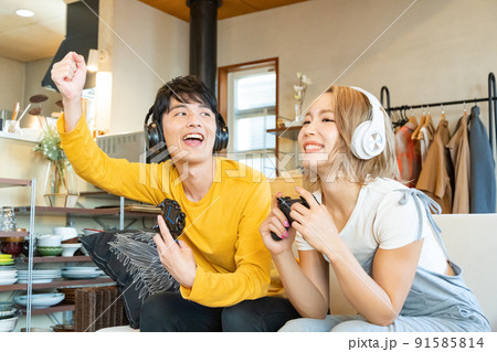 テレビゲームで遊ぶ若い男女 91585814