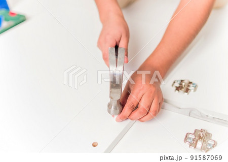 Latin Bolivian strong and independent success woman assembly and repair furniture with hammer. 91587069