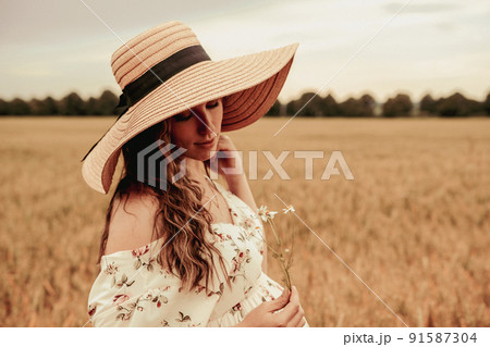 Woman wheat field nature. Happy young woman in sun hat in summer wheat field at sunset. Copy space, sunset, flare light, summer season. Boho chic style. Woman wheat field nature. Happy young woman in sun hat in summer wheat field at sunset. Copy space, sunset, flare light, summer season. Boho chic style. 91587304