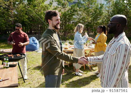 Two happy young intercultural men greeting each other by handshake Two happy young intercultural men greeting each other by handshake 91587561