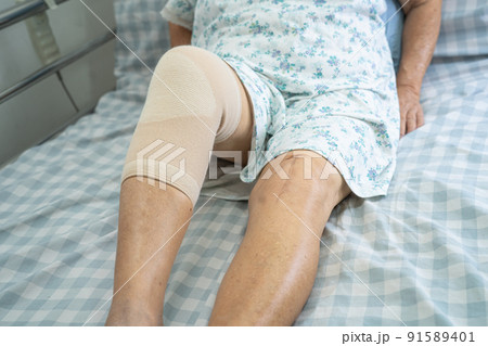 Asian senior or elderly old lady woman patient with knee support pain joint on bed in nursing hospital ward, healthy strong medical concept. Asian senior or elderly old lady woman patient with knee support pain joint on bed in nursing hospital ward, healthy strong medical concept. 91589401