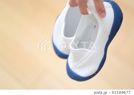 上履きを持つ女の子の手 91589677