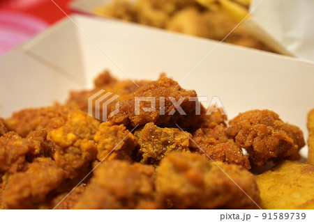 Close-up Fried breaded chicken fillet in white cardboard box isolated on burred background 91589739
