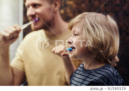 Boy Brushing Teeth with Father 91590329