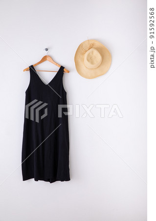 白い壁に掛けられた黒いワンピース　One piece and straw hat 91592568