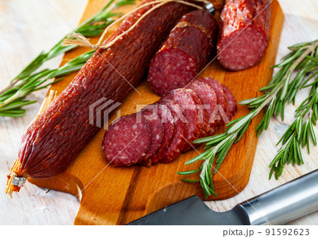Fresh smoked russian sausage cut in slices on wooden surface 91592623