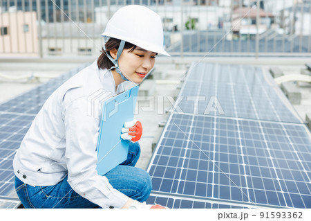 ソーラーパネルの点検をする女性作業員 91593362