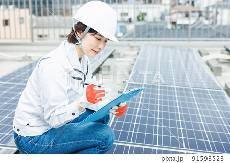 ソーラーパネルの点検をする女性作業員 91593523