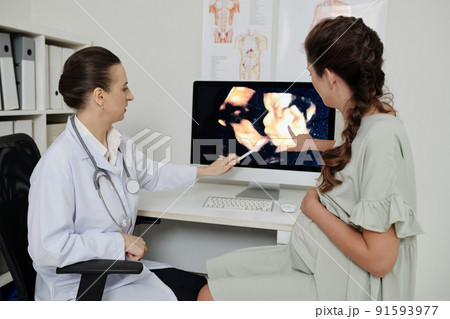 Gynecologist discussing baby scan with patient Gynecologist discussing baby scan with patient 91593977