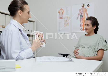 Doctor presenting information to pregnant woman 91593990